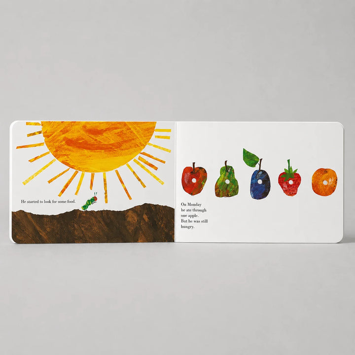 Children's book open to a page with a sun illustration and colorful fruits on a gray background