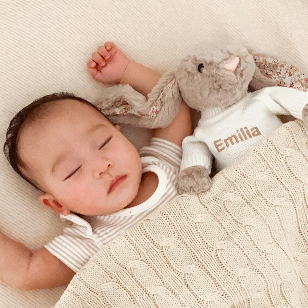 Baby sleeping with Jellycat Bashful Blossom Bea Beige Bunny and covering in Cream Cable Knit Blanket