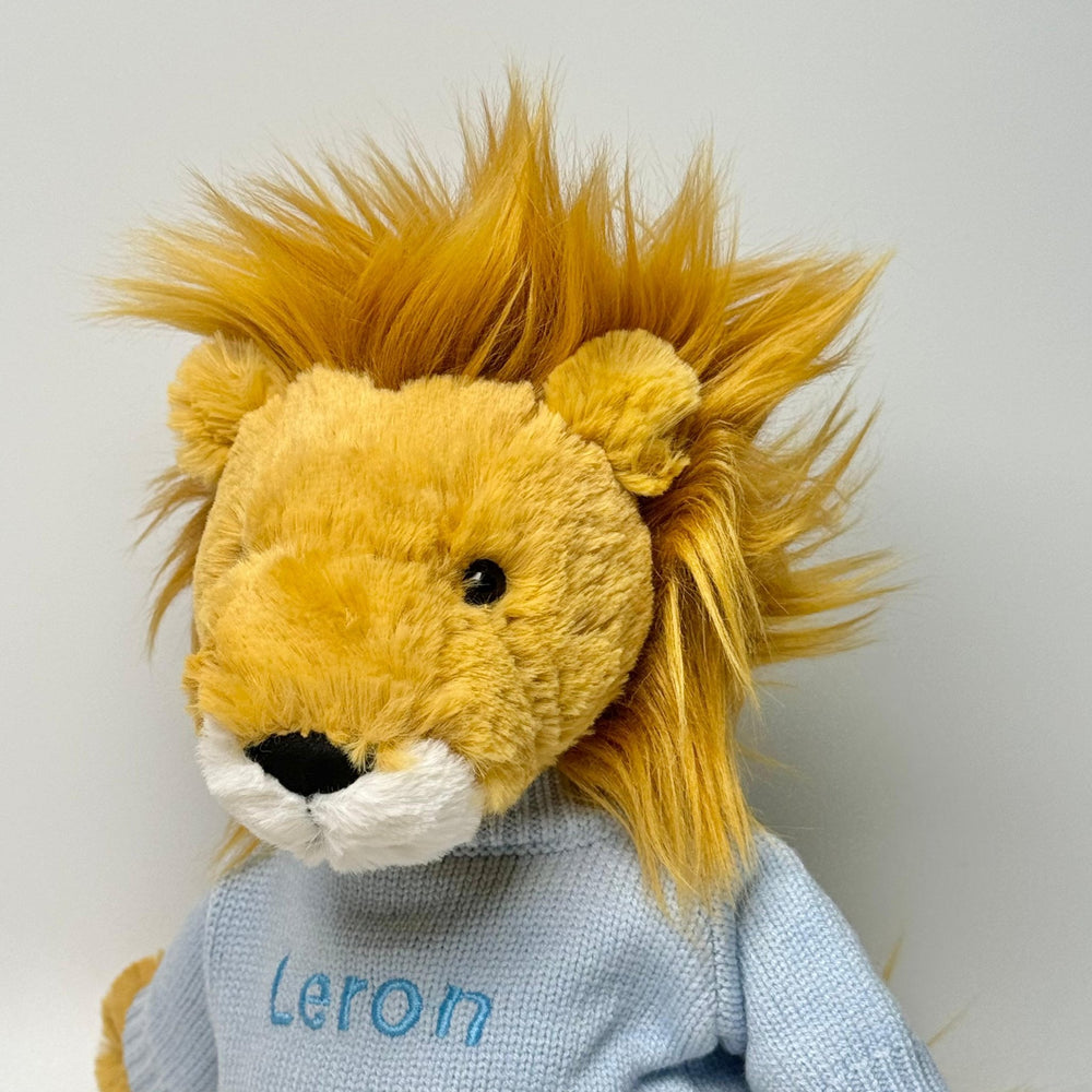 Jellycat Bashful Lion in personalised blue jumper with "Leron" in blue thread