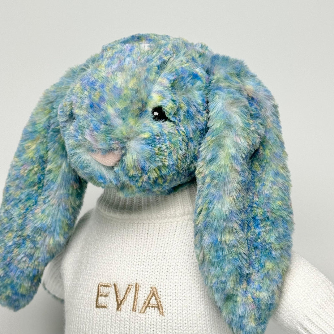 Jellycat Bashful Luxe Azure Bunny in cream jumper personalised with "EVIA" in beige thread