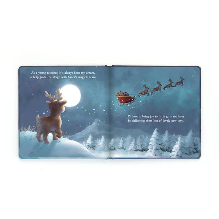Open “Mitzi Reindeer’s Dream” board book showing Mitzi gazing at Santa’s sleigh flying through a snowy moonlit sky and dreaming of joining Santa’s magical team.