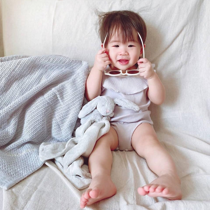 Baby playing with Jellycat Bashful Grey Bunny Soother