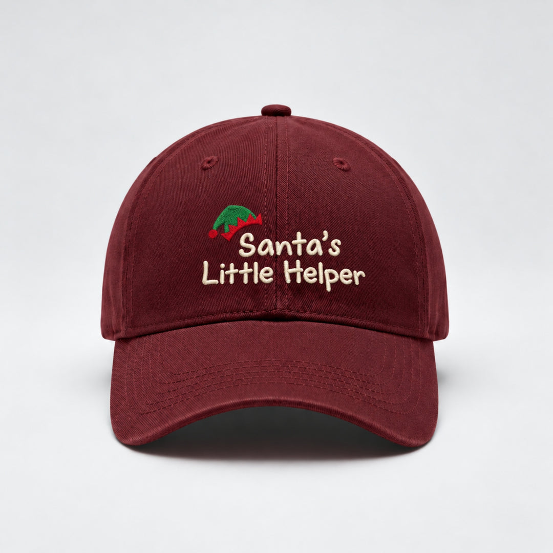 Burgundy kids' Christmas baseball cap embroidered with “Santa's Little Helper” in cream thread, featuring a festive green and red elf hat design.