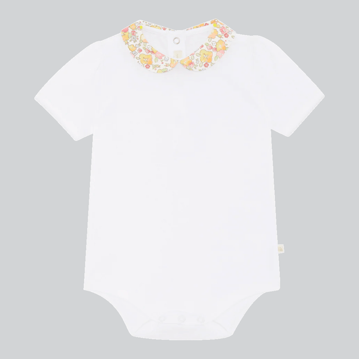 Marie Chantal's White baby onesie with floral ruffle collar 