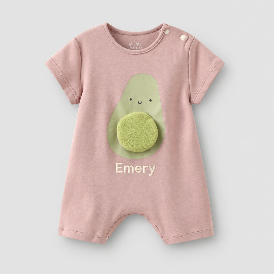 Dusty pink short-sleeve baby romper with a smiling avocado design, 3D textured avocado stone, and the name “Emery” personalised on the front.