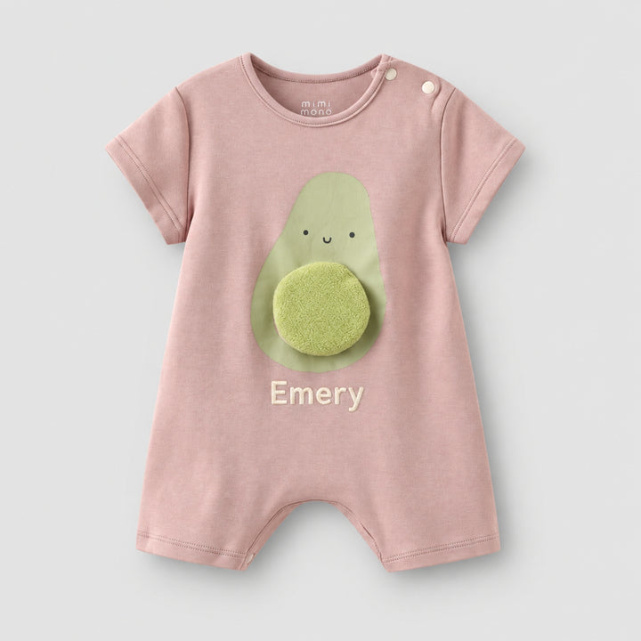 Dusty pink short-sleeve baby romper with a smiling avocado design, 3D textured avocado stone, and the name “Emery” personalised on the front.