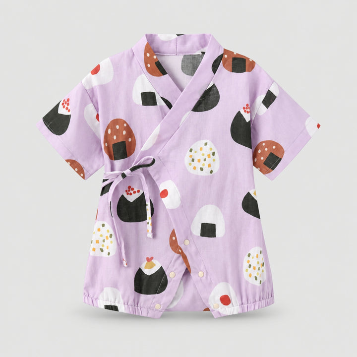 Lilac kimono-style baby romper with colourful onigiri rice ball prints, wrap-front tie detail, short sleeves and snap closures.
