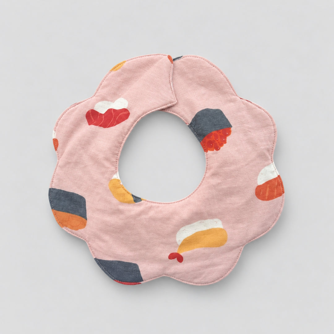 Back view of a pink scalloped baby bib featuring colourful sushi illustrations and a rounded neck opening.