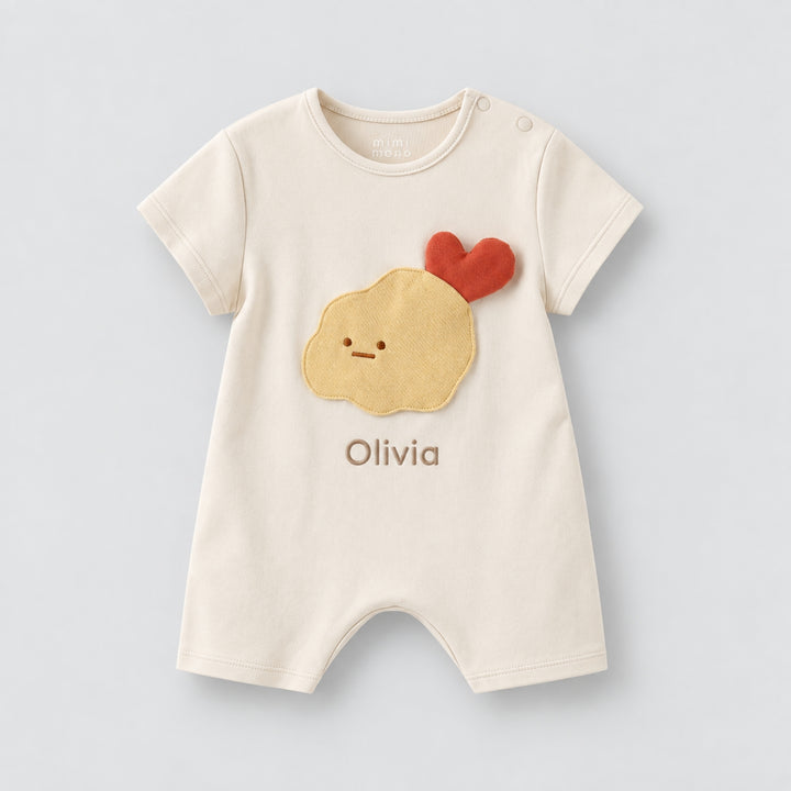 Cream short-sleeve baby romper with a yellow tempura character, red heart detail, and the name “Olivia” personalised on the front.