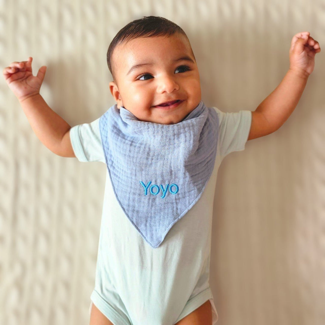 Baby wearing Blue Muslin Bib with "Yoyo"personalised 