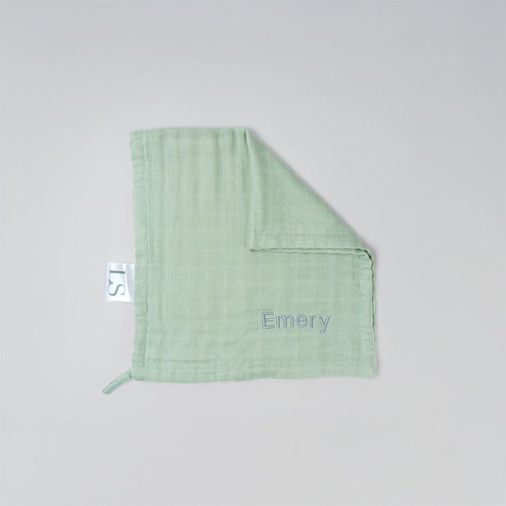 Green muslin wash cloth with 'Emery' embroidered on it.