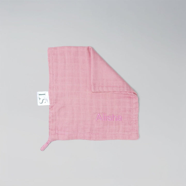 Pink muslin washcloth with 'Alisha' embroidered on it.
