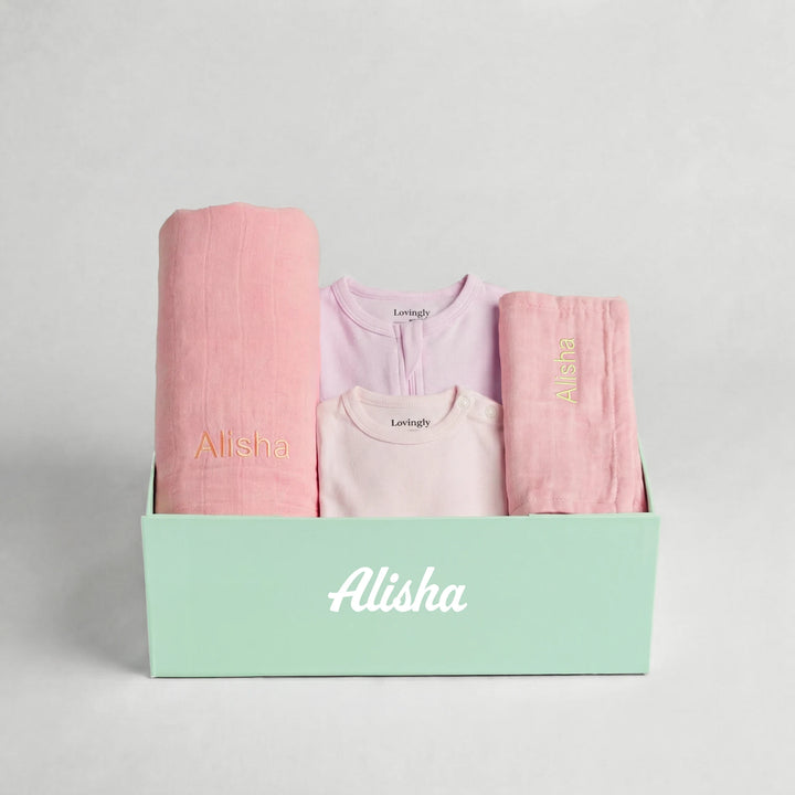 Luxury pink bamboo baby gift set including swaddle, wash cloth, babygrow and bodysuit