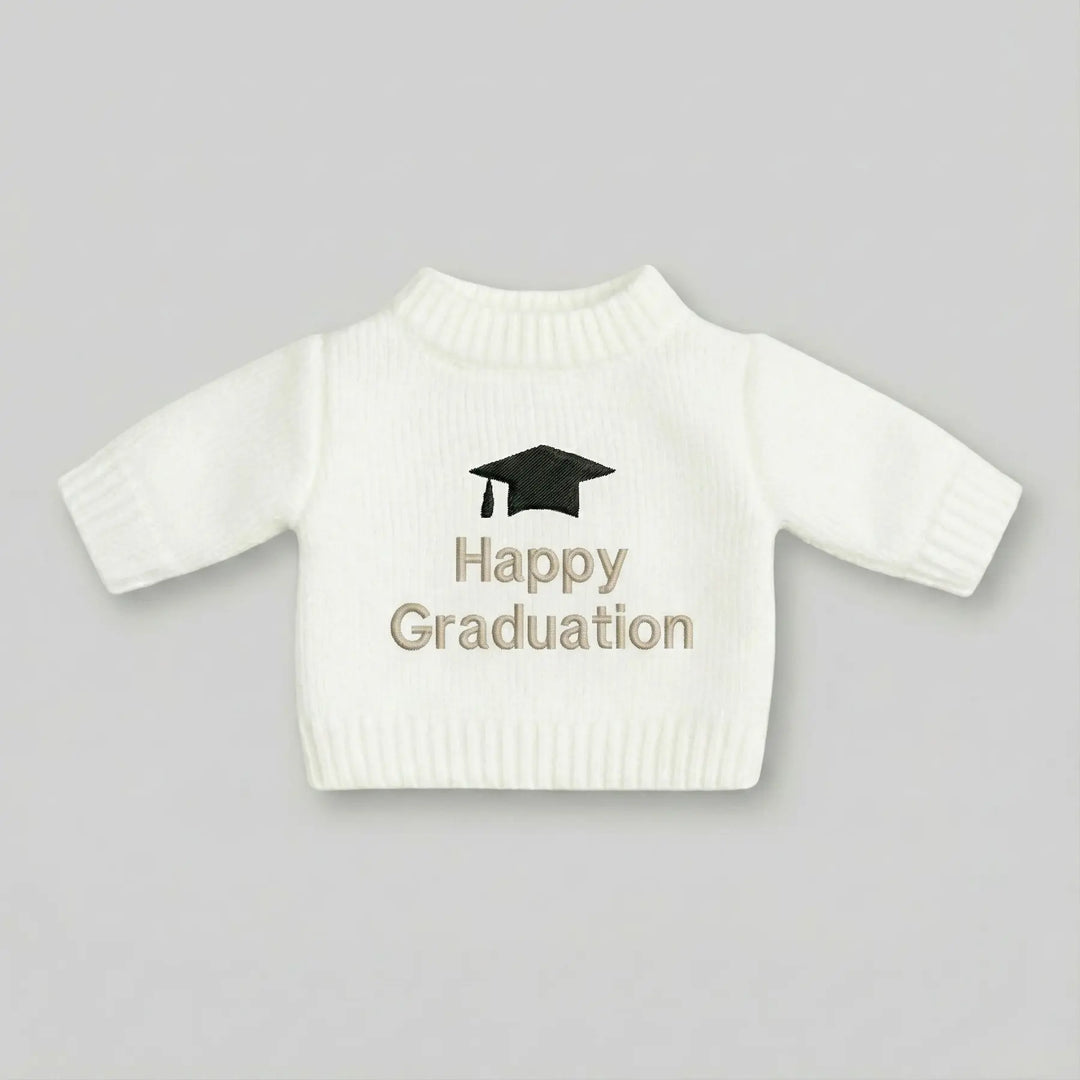 White sweater with 'Happy Graduation' text and graduation cap on a gray background