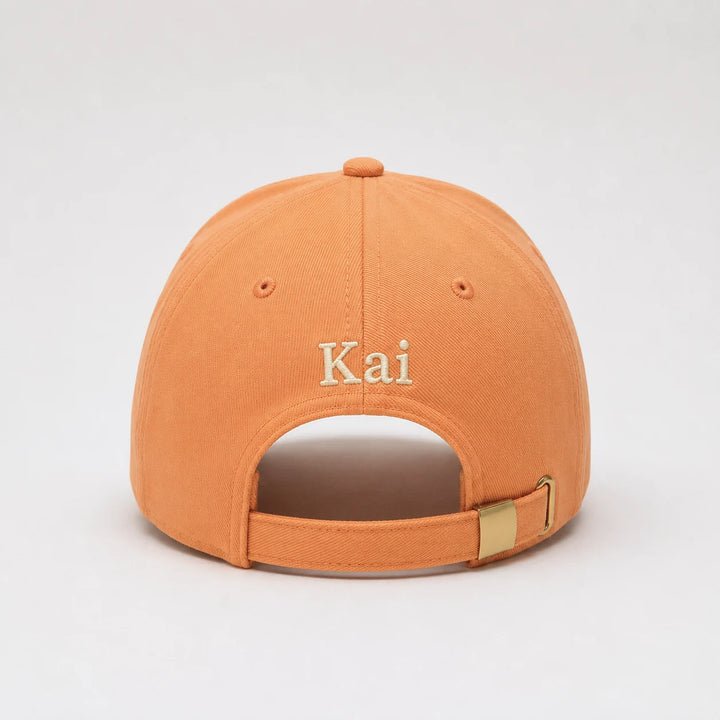Orange cap with 'Kai' embroidered on the back against a light gray background
