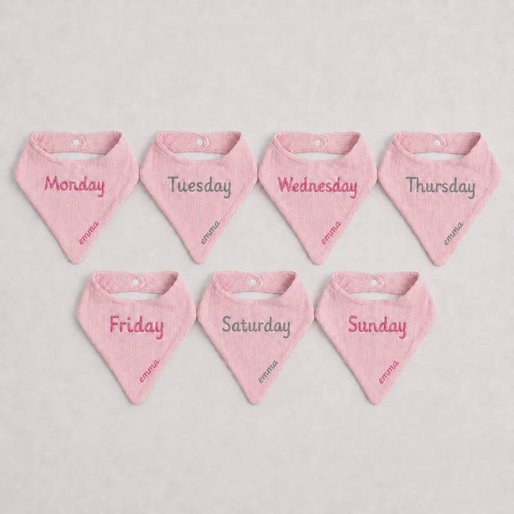 Set of seven pink baby bandannas with days of the week text embroidery