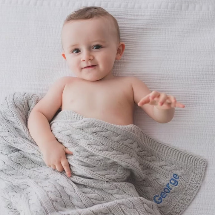 Baby covered in Personalised Grey Cable Knit Blanket