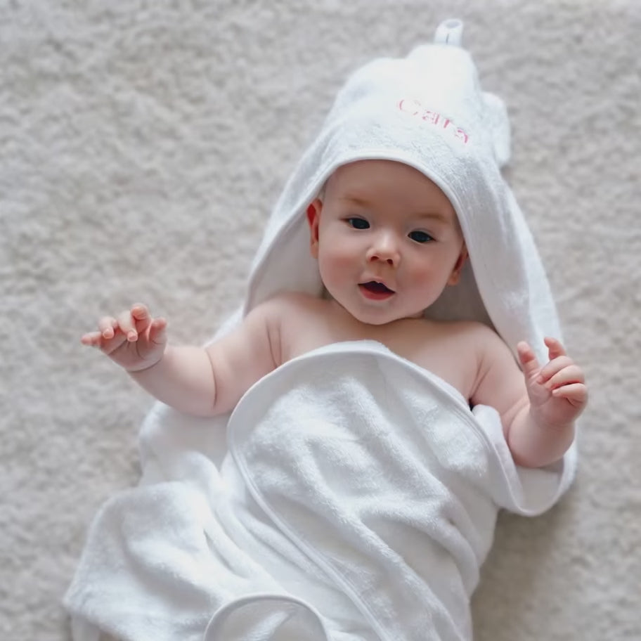 Baby using the personalised white hooded towel with ears