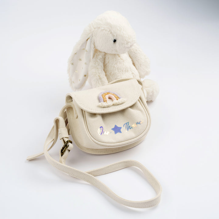 Plush bunny with bag featuring rainbow design