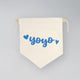 Beige drawstring bag with blue text 'yoyo' on a gray background