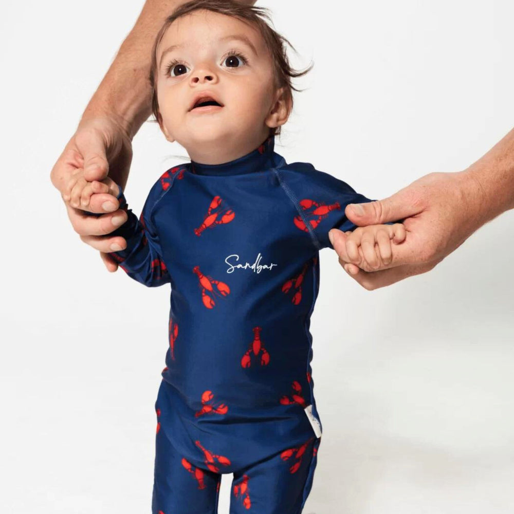 Baby wearing Sandbar Swimsuit in Red Lobster Design