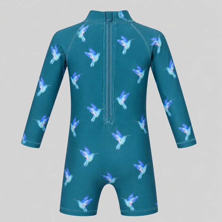 Teal hummingbird-print long-sleeve baby swimsuit with high neckline and short legs, photographed on a light grey studio background.