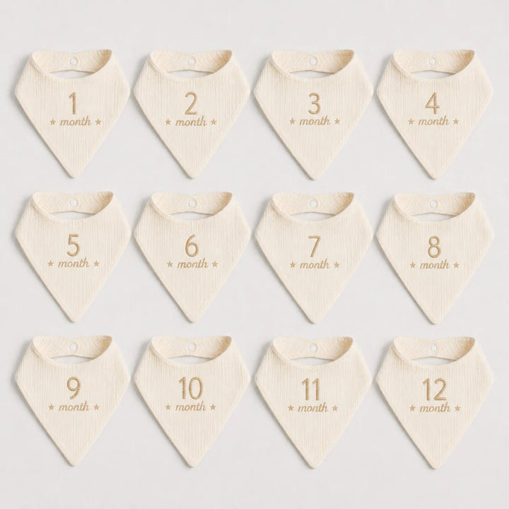 Set of 12 baby bandannas with month markings on a light background