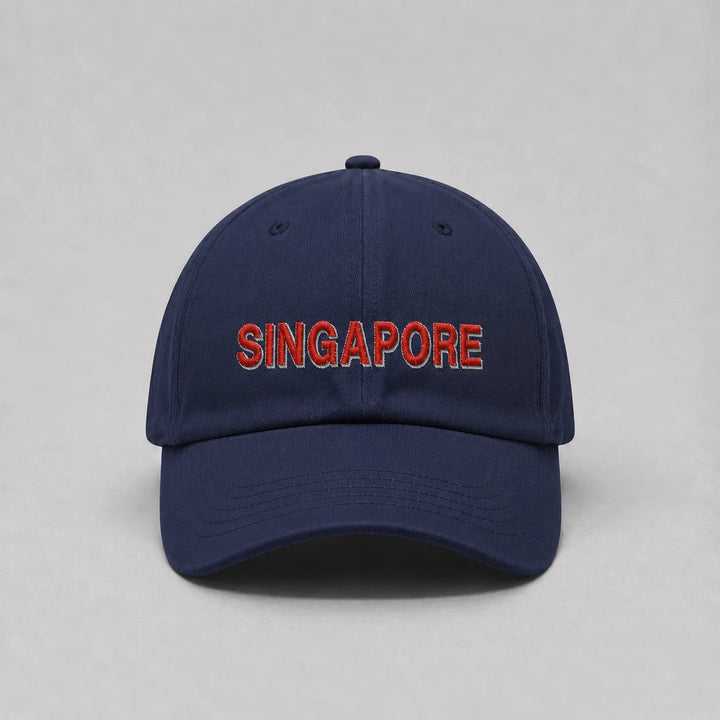 A navy blue baseball cap with 'SINGAPORE' embroidered in red letters with a white outline on the front, set against a plain gray background.