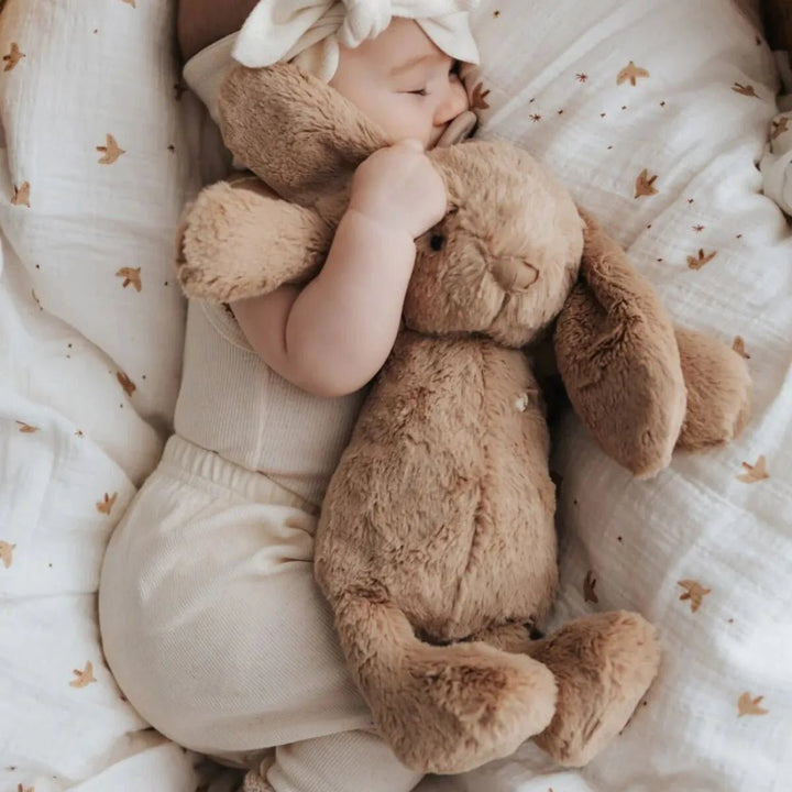 Baby hugging Snuggle Bunnies Penelope Bunny - Caramel to sleep