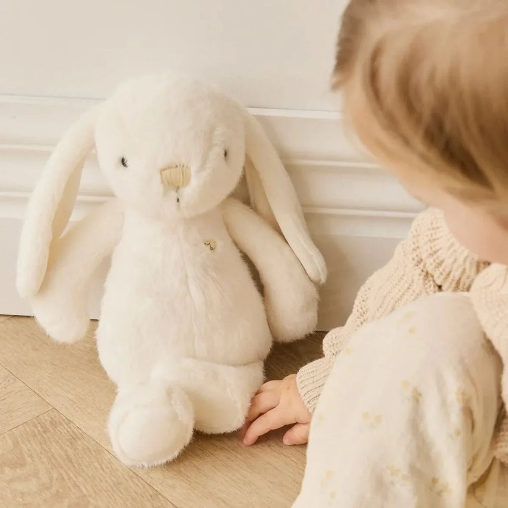 Child sitting by Snuggle Bunnies Penelope - Marshmallow