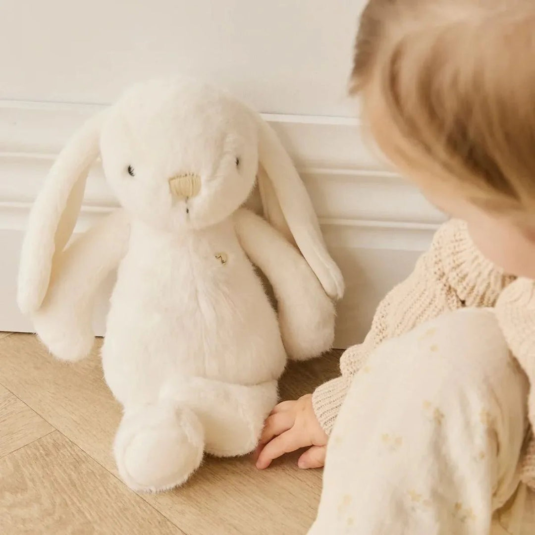 Child sitting by Snuggle Bunnies Penelope - Marshmallow