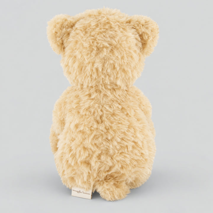 Rear view of a fluffy cream Arthur teddy bear showing its soft plush fur, rounded ears and small fabric label against a light grey studio background.