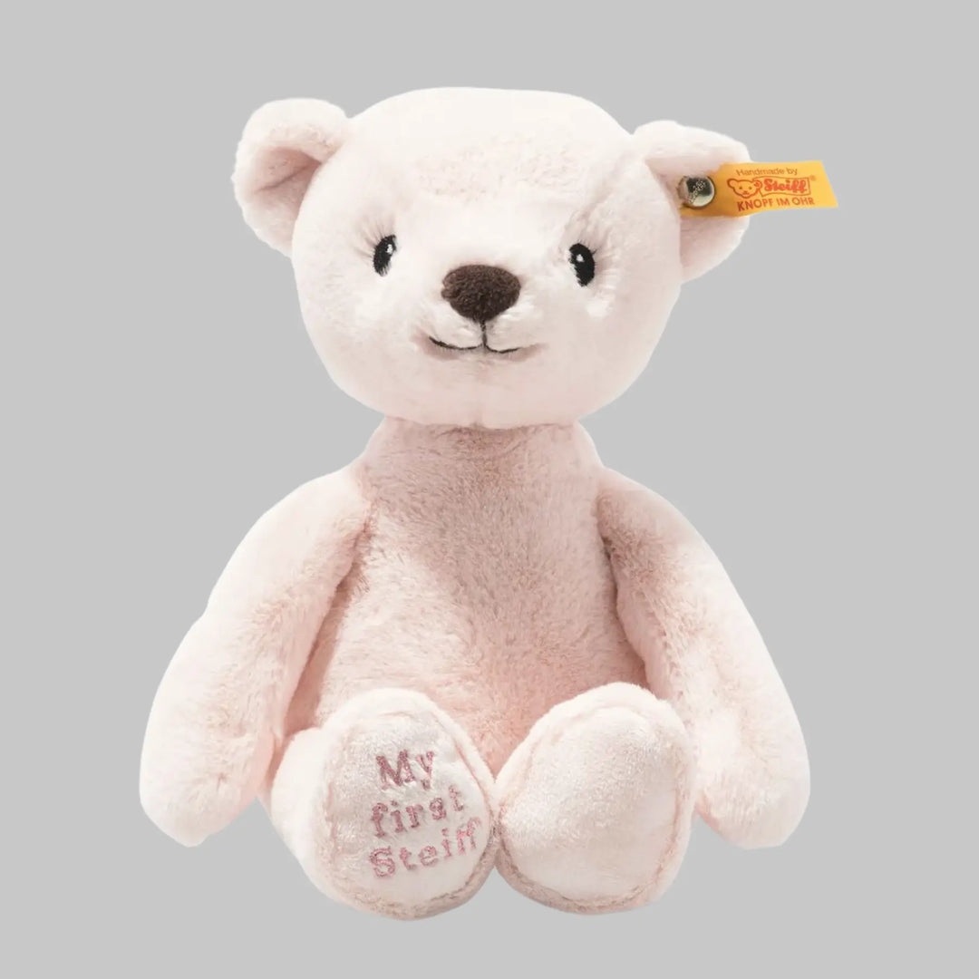 Close-up of Steiff Teddy Bear with signature ear tag – soft pink plush toy for babies