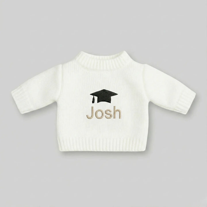 White sweater with 'Josh' and a graduation cap design on a gray background