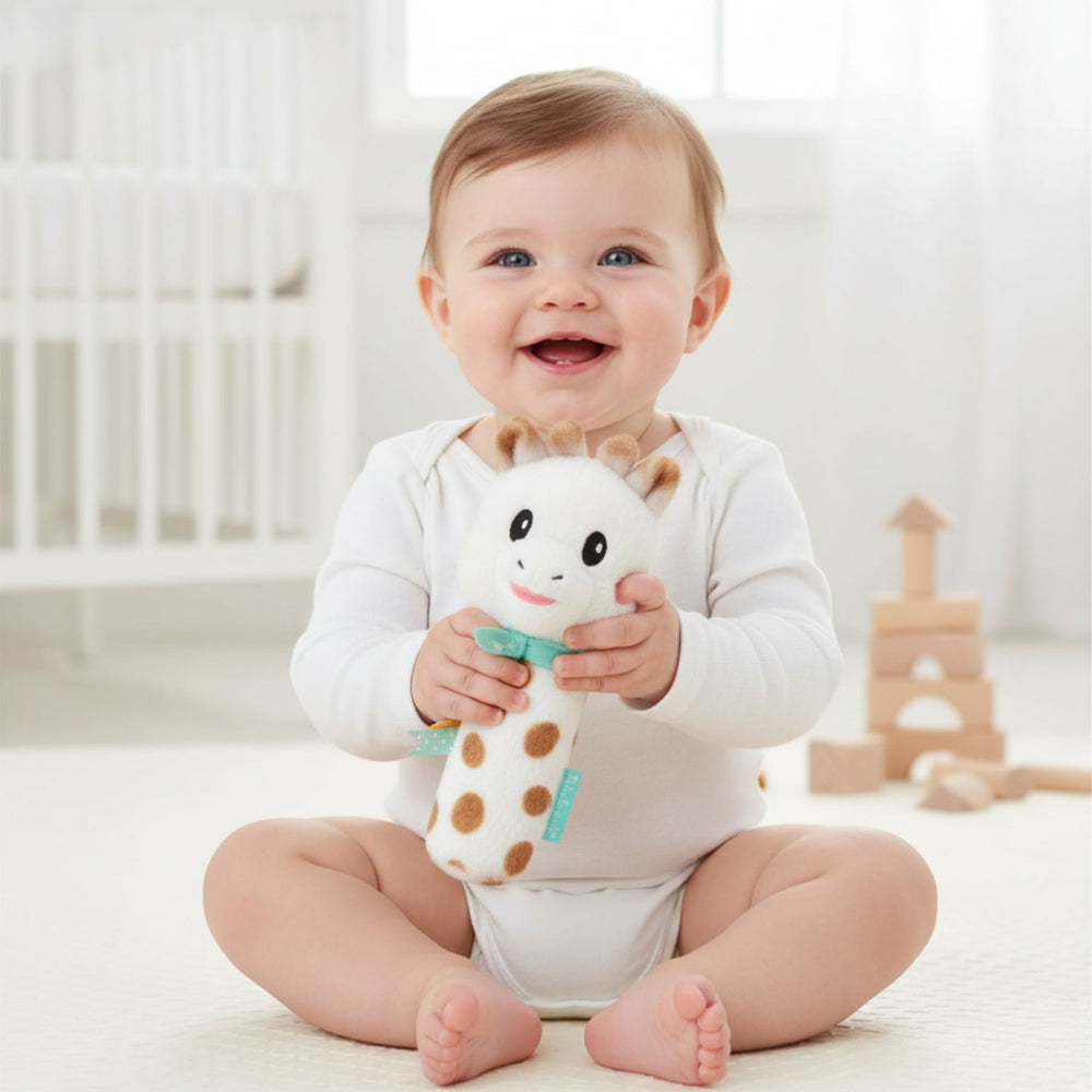 Baby holding Sophiesticated Pouet Rattle 

