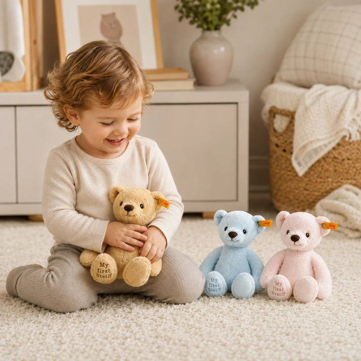 Toddler Playing with My First Steiff Teddy Bears in Blue, Pink and Golden Beige in a Cozy Nursery Setting