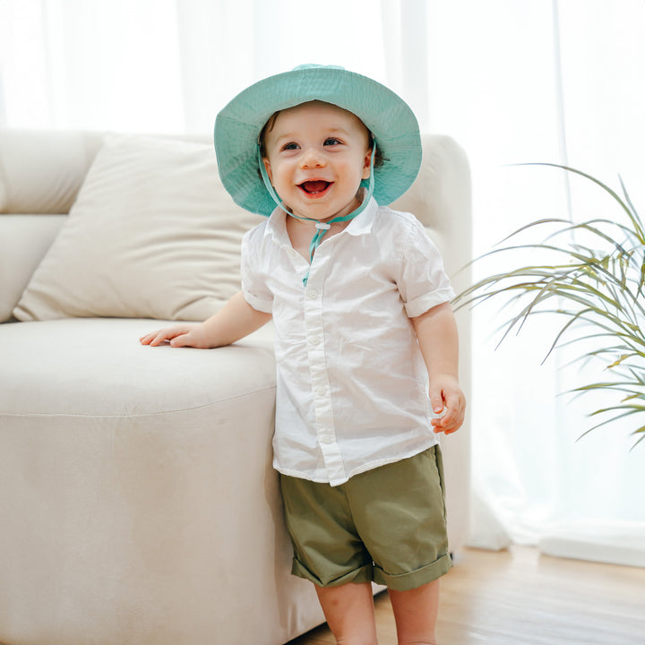 Toddler wearing green sun hat 