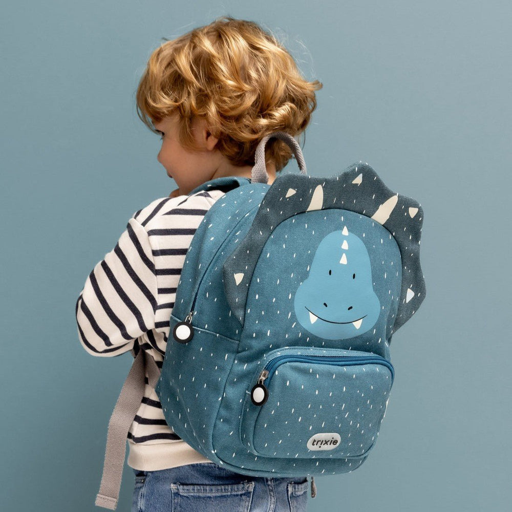 Child wearing a Trixie Mr. Triceratops Backpack