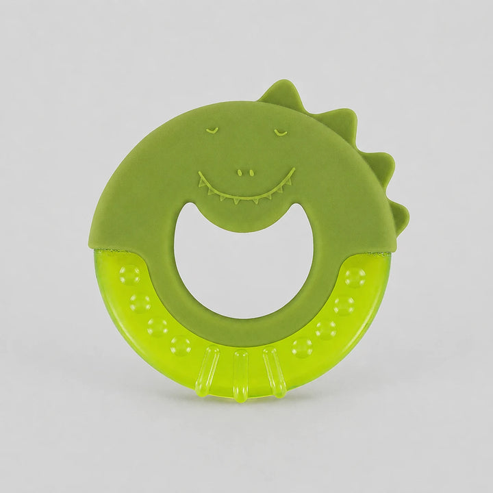 Trixie Mr Dino Cooling Teether. A green silicone baby teether with a dinosaur face and textured bottom, photographed on a neutral light gray background.