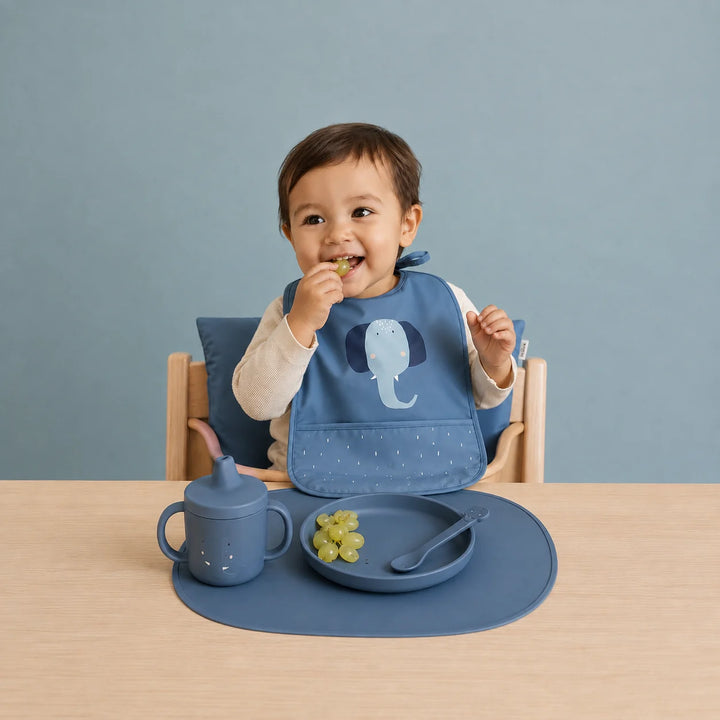 Toddler wearing Trixie Mr Elephant waterproof baby bib while eating