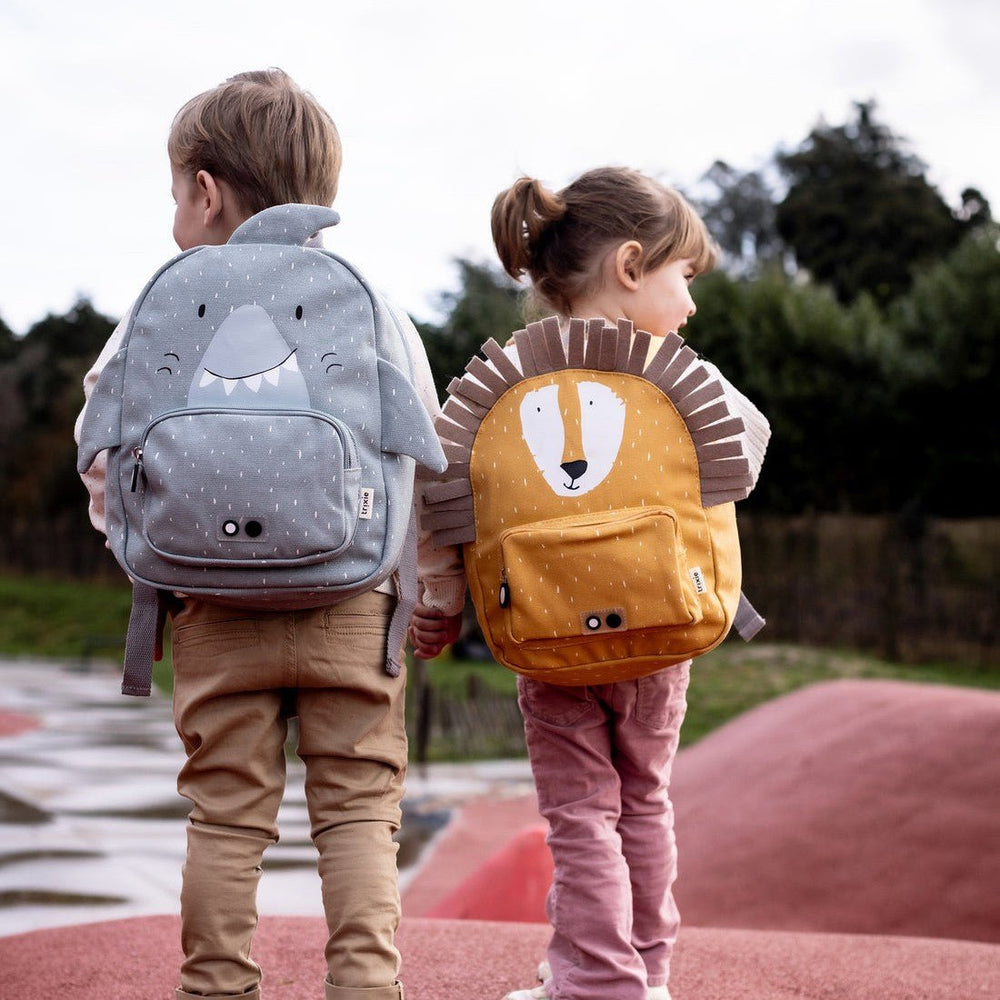 Two children with Trixie backpacks on a playground.