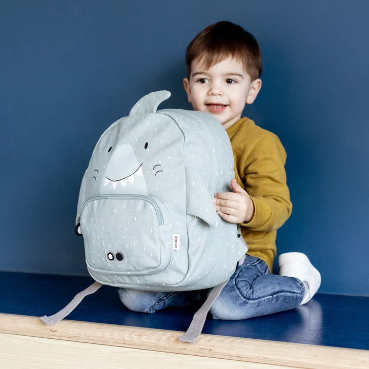 Child holding a Trixie Shark backpack