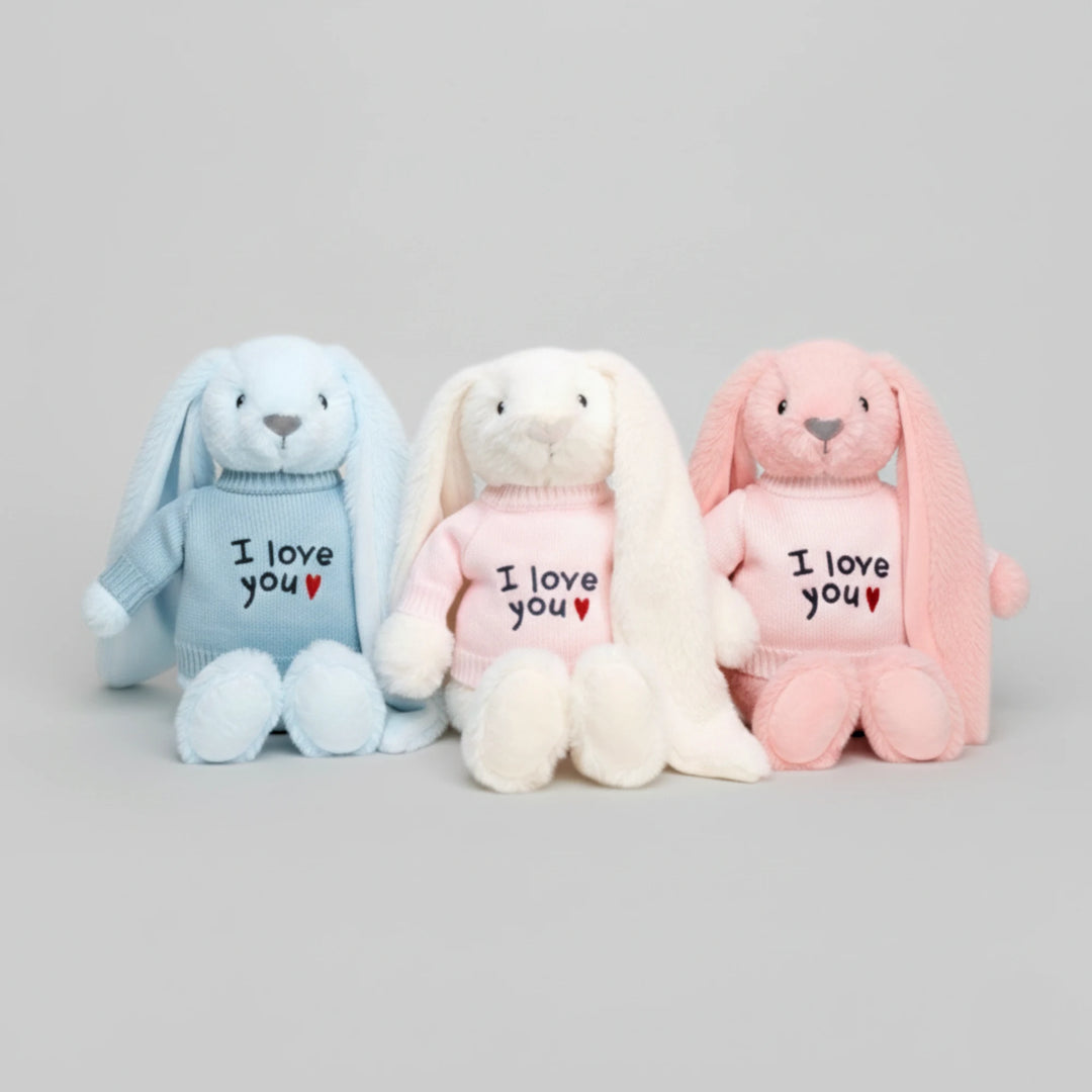 Three plush bunnies in blue, white, and pink with 'I love you' text on a gray background