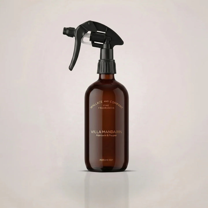 An amber glass spray bottle with a black trigger sprayer, featuring gold text that reads 'VILLA MANDARIN' and 'Mandarin & Pepper'.