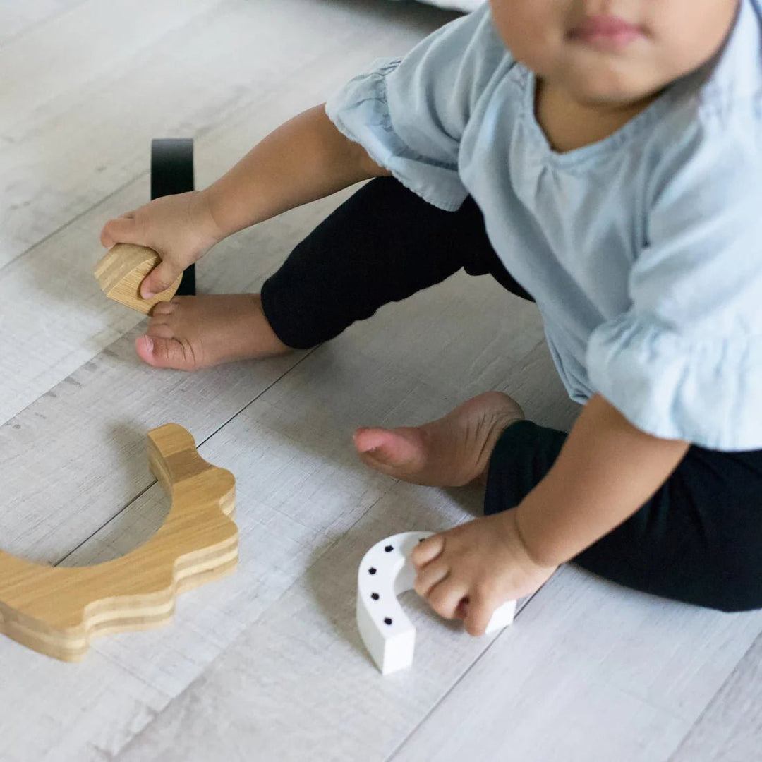 Baby playing with Wee Gallery Nesting Toy 