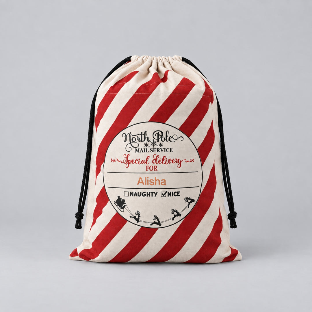 Cream Christmas drawstring sack with bold red candy-cane stripes, North Pole Mail Service special delivery label and the name “Alisha” personalised on the front.
